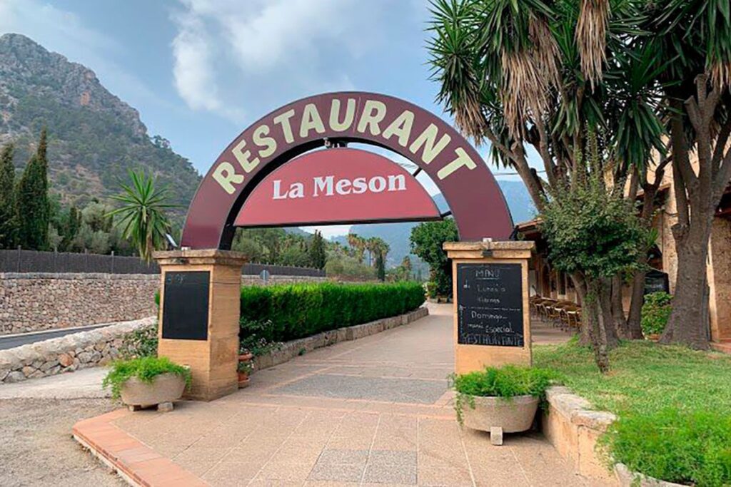 Entrada del restaurante La Mesón con el arco y la Serra de Tramuntana al fondo